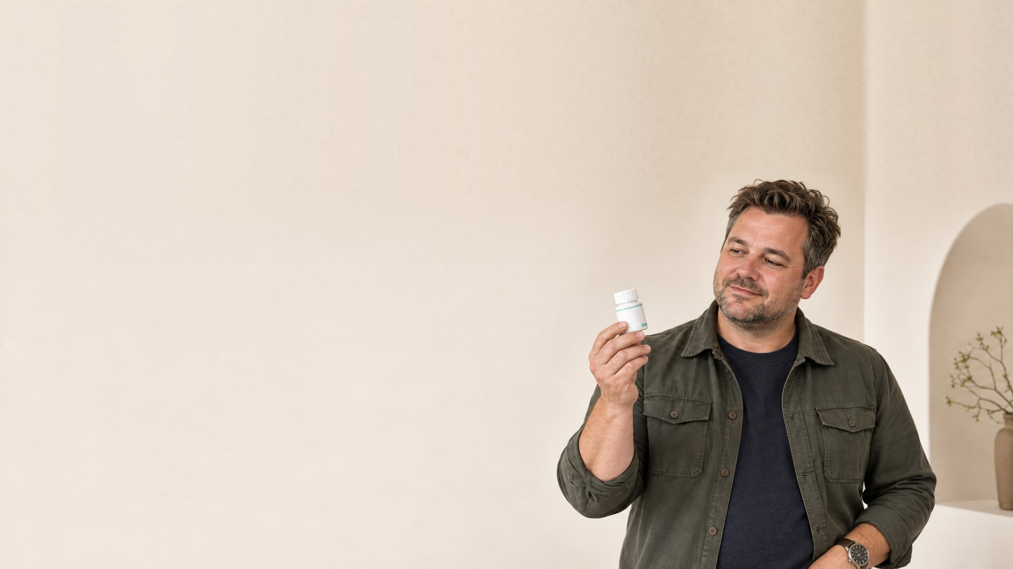 Man bekijkt een wit potje met tabletten voor medisch afvallen, tegen een rustige lichte achtergrond