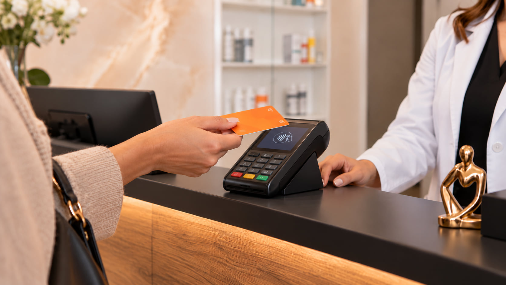 Klant betaalt met een oranje kaart aan de balie van een apotheek bij een medewerker in witte jas