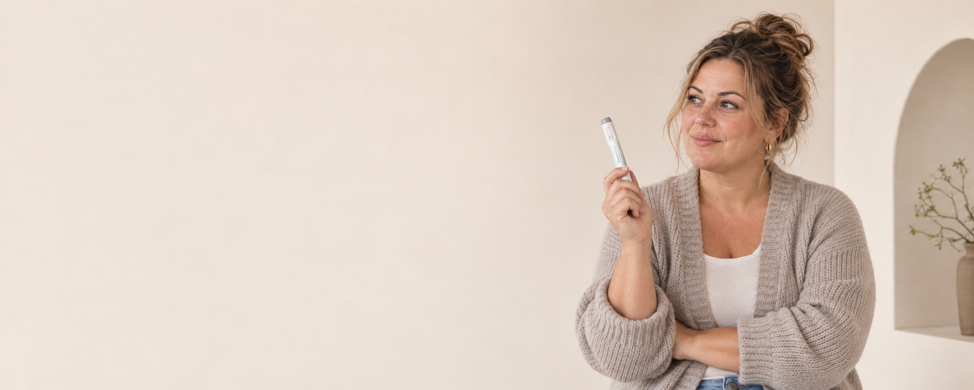 Vrouw houdt een witte injectiepen vast tegen een rustige beige achtergrond